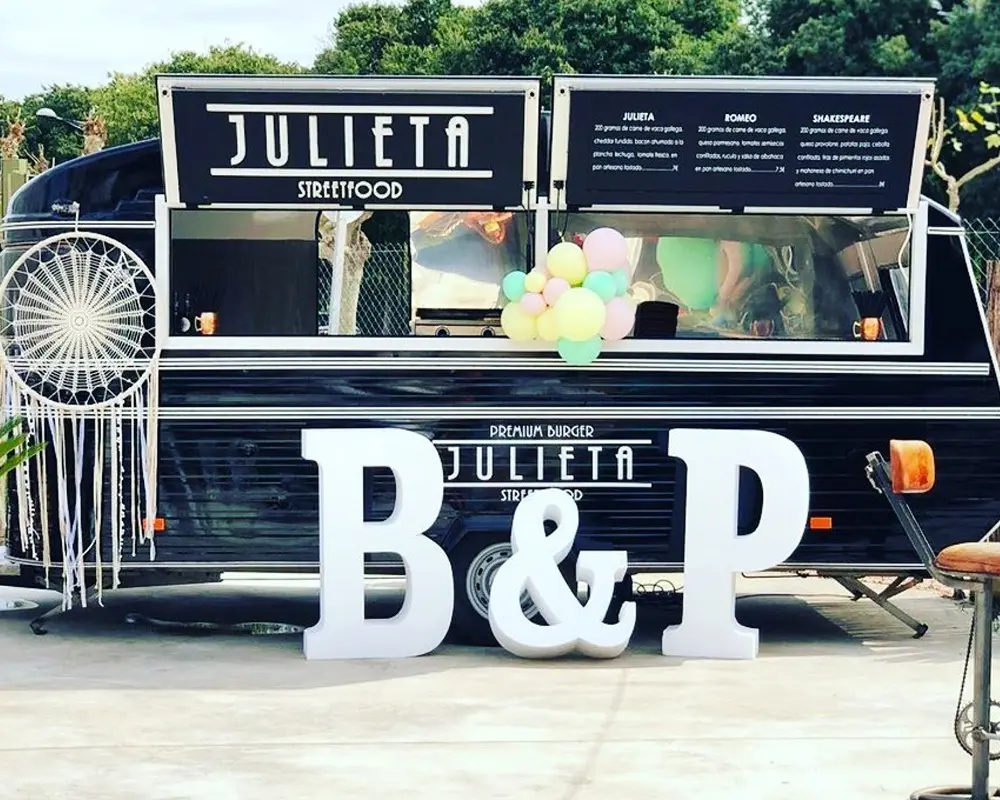 Food truck Julieta Streetfood decorado con globos y menú de hamburguesas Julieta, Romeo y Shakespeare.