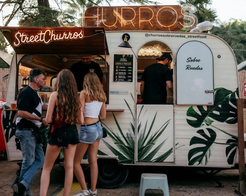 Food truck Street Churros atendiendo clientes y mostrando menú de churros y precios.